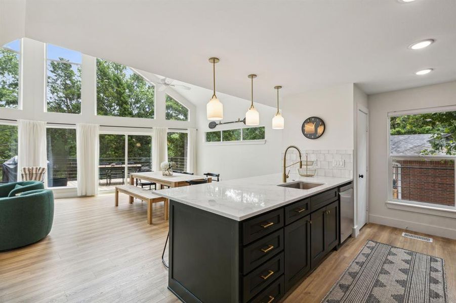 Kitchen featuring sink, plenty of natural light, light stone counters, and stainless steel dishwasher