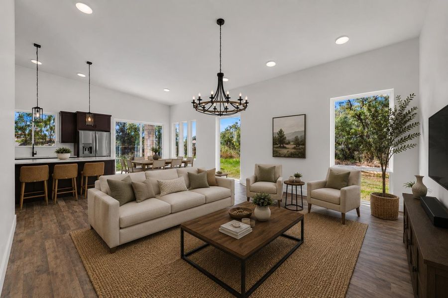 Virtually staged; an open floor plan connects the living area to the kitchen under high ceilings.