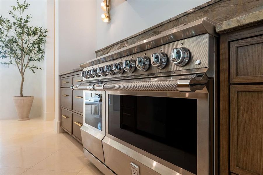 Kitchen view of range with two ovens and dark brown cabinetry