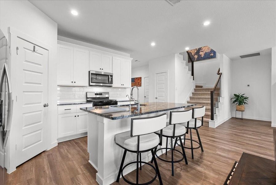 Chef’s eat-in island kitchen boasts stainless steel appliances, 42” cabinets with crown molding, lengthy countertops, breakfast bar seating, and a spacious pantry.