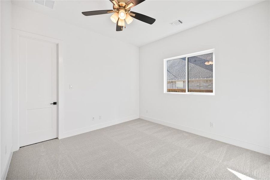 Carpeted spare room featuring baseboards and a ceiling fan Carpeted spare room featuring baseboards and a ceiling fan
