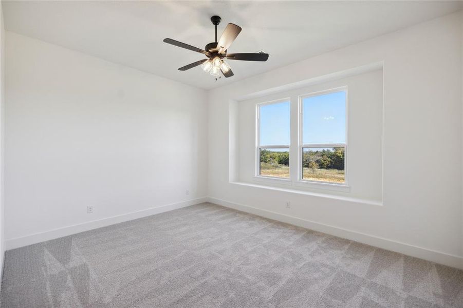 Carpeted spare room with ceiling fan