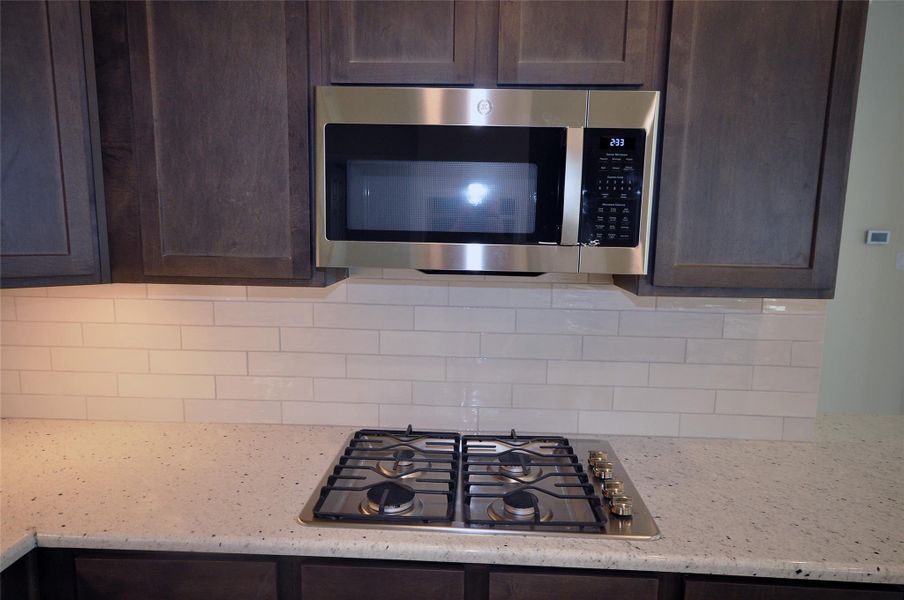 Gas cooktop with a directly vented microwave above.