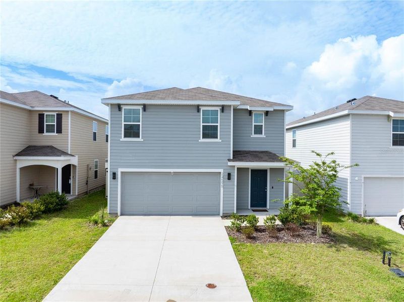 Front exterior of a new home in Avalon Woods, Newberry, FL, highlighting curb appeal (Image 2). Front exterior of a new home in Avalon Woods, Newberry, FL, highlighting curb appeal (Image 2).