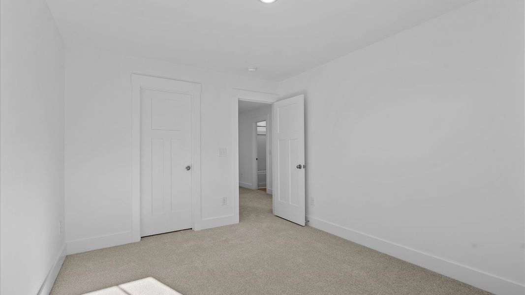 First-class secondary bedroom with comfortable carpeted flooring and generous closet space