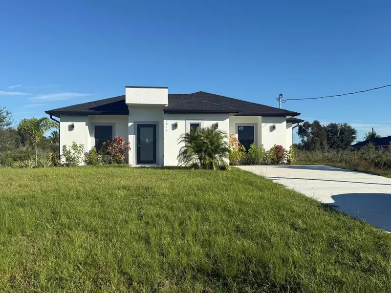 Front exterior of a new home in , Lehigh Acres, FL, highlighting curb appeal (Image 1).