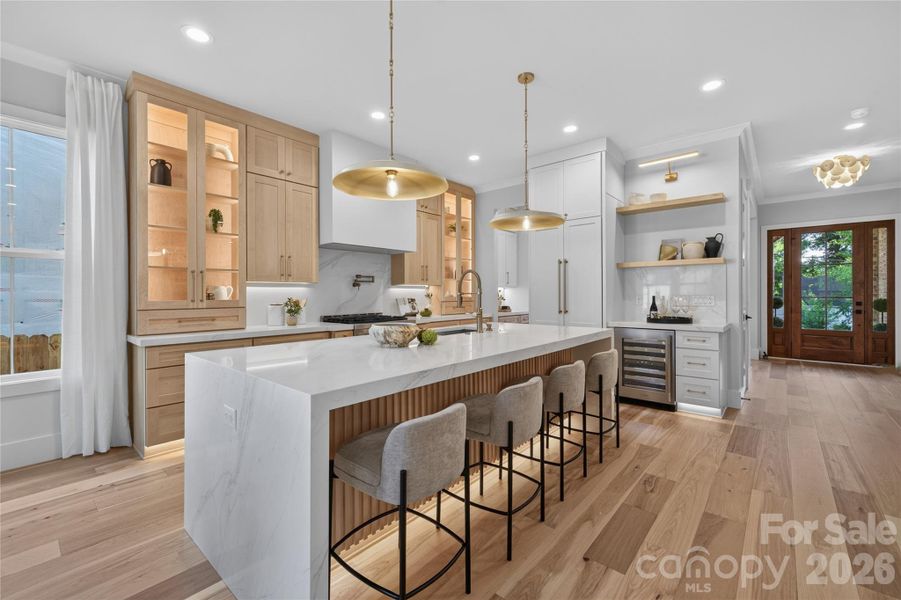 Gourmet kitchen with all the bells and whistles! Interior cabinet lighting, dimmable toe kick & under cabinet lighting, panel ready refrigerator, beautifully appointed maple & off white two toned cabinetry, 2.5" Calcutta Silverlight countertop with waterfall edge and Calcutta Quartz backsplash.
