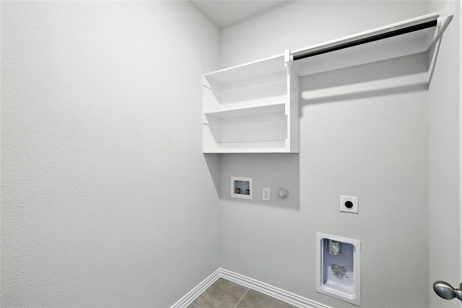 Laundry area with gas dryer hookup, electric dryer hookup, washer hookup, and tile patterned flooring Laundry area with gas dryer hookup, electric dryer hookup, washer hookup, and tile patterned flooring