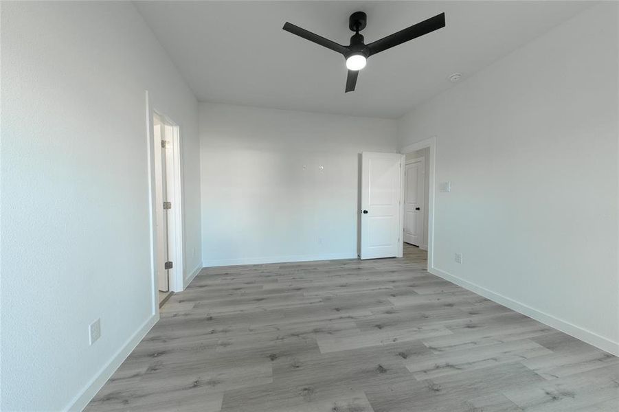 Unfurnished room featuring ceiling fan and light wood-type flooring