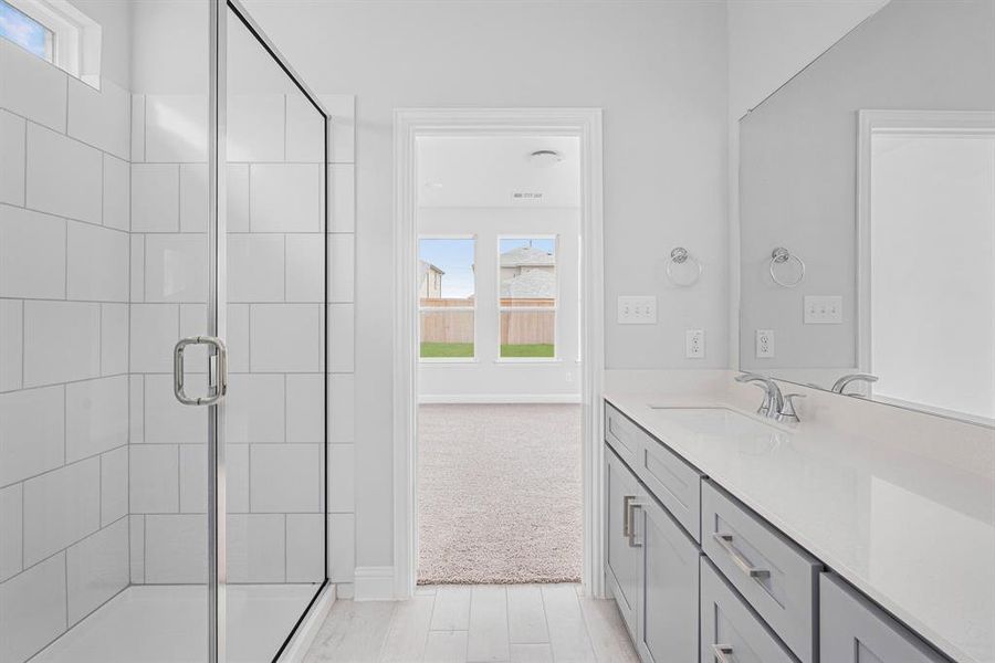 Bathroom featuring a shower stall, visible vents, baseboards, and vanity