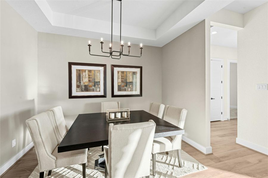 Dining space featuring light wood-type flooring, a tray ceiling, and recessed lighting Dining space featuring light wood-type flooring, a tray ceiling, and recessed lighting