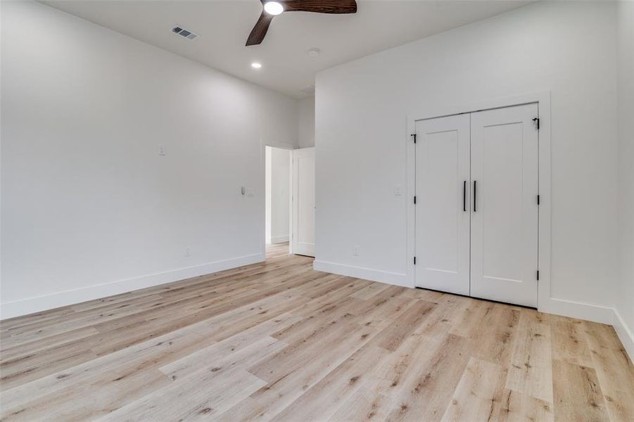 Unfurnished bedroom with light wood-style flooring, ceiling fan, a closet, and recessed lighting