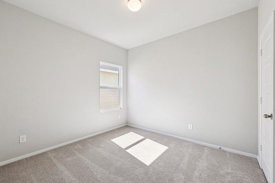 Image of a bedroom with grey walls, tan carpeting, a window and white trim