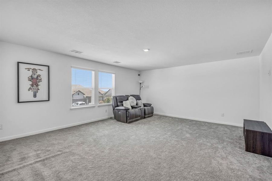 Spacious room featuring light gray carpeting and white walls Spacious room featuring light gray carpeting and white walls