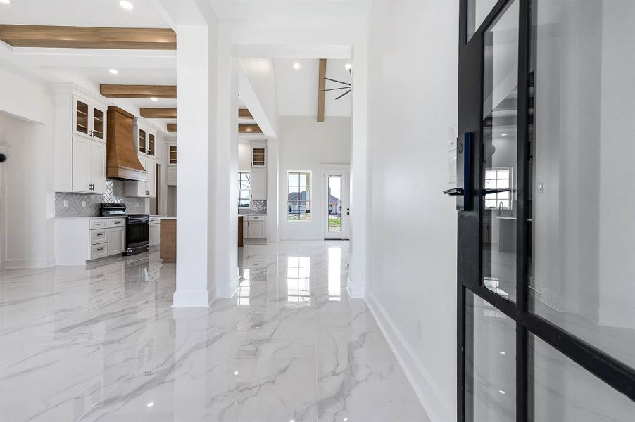 Bright, open entryway featuring sleek tile flooring, warm wood accents, and an open layout that flows into the kitchen and living areas. Bright, open entryway featuring sleek tile flooring, warm wood accents, and an open layout that flows into the kitchen and living areas.