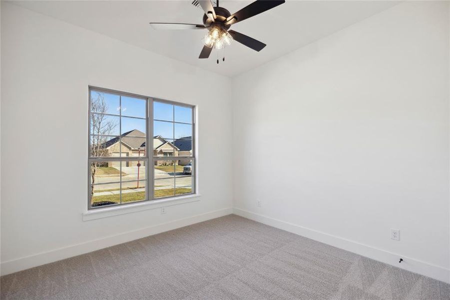 Carpeted spare room with ceiling fan