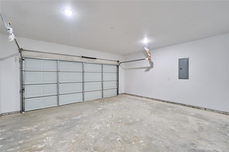 Two-car garage featuring a paneled overhead door, concrete flooring, and recessed ceiling lighting