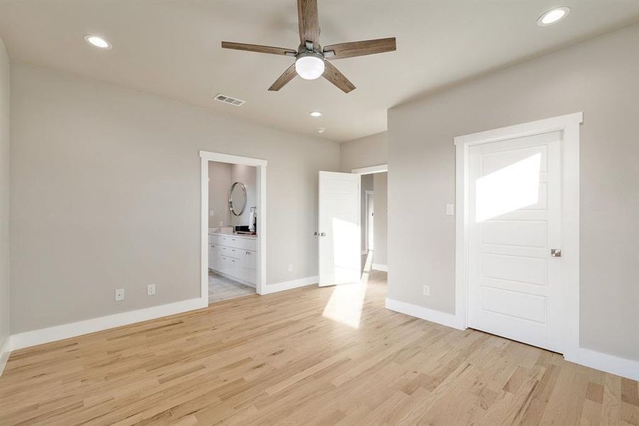 Unfurnished bedroom featuring ensuite bath, light wood-type flooring, and ceiling fan