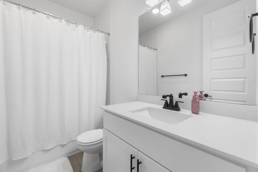 Bathroom 2 with vanity, shower / tub combo with curtain, toilet, and tile patterned flooring