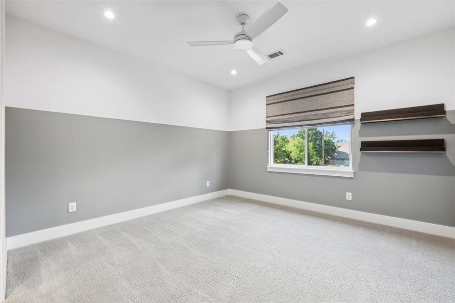 Carpeted spare room with ceiling fan