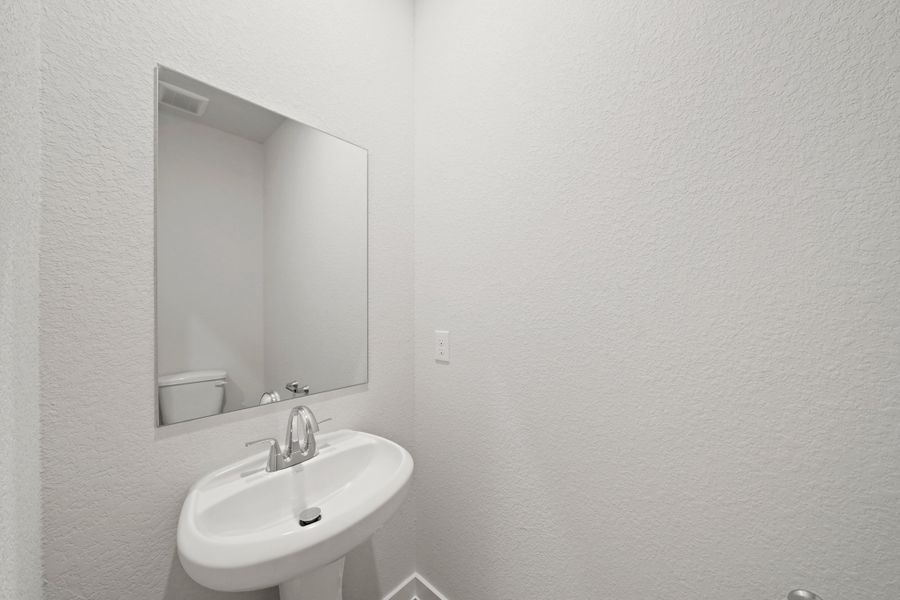 A bathroom with a mirror and sink. A bathroom with a mirror and sink.