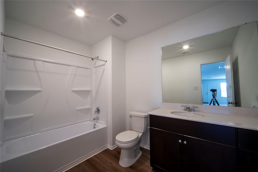 Full bathroom with vanity, dark wood-style floors, bathing tub / shower combination, and recessed lighting