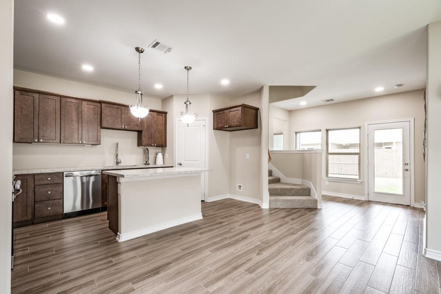 Stylish kitchen with island, stainless appliances, and rich cabinetry. Stylish kitchen with island, stainless appliances, and rich cabinetry.