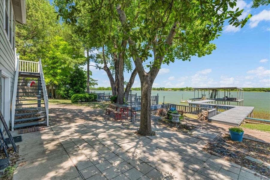 View of patio featuring a water view and a boat dock