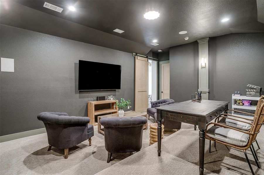 Carpeted home office with a textured wall, a barn door, a textured ceiling, and recessed lighting