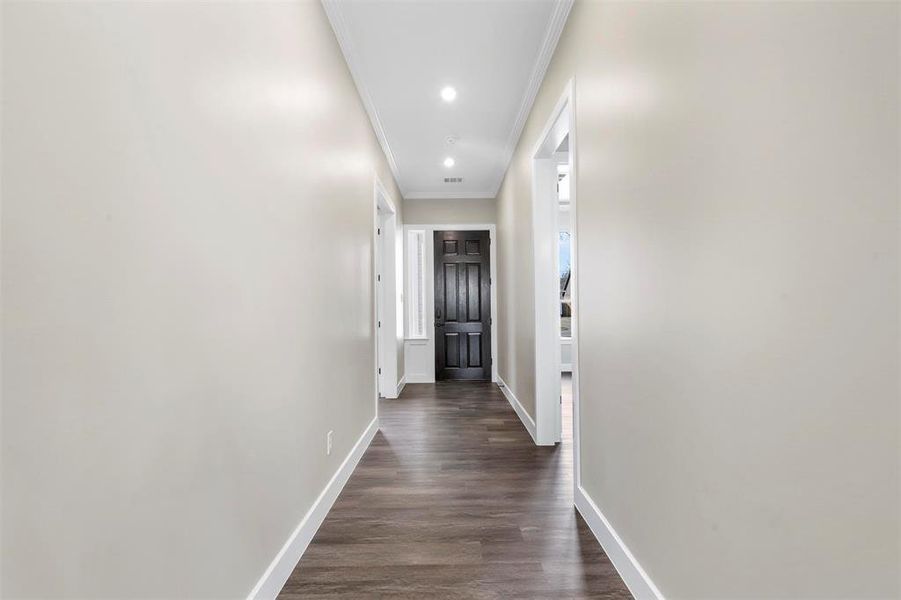 Corridor featuring ornamental molding and dark hardwood / wood-style floors