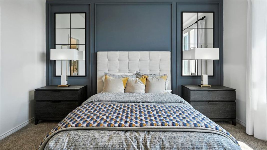 Feature wall with panel molding and a rich blue finish, complemented by a tufted headboard