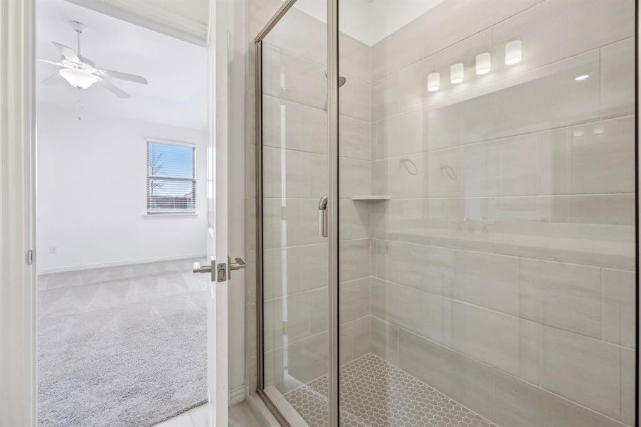 Primary Bathroom with ceiling fan and a shower with shower door