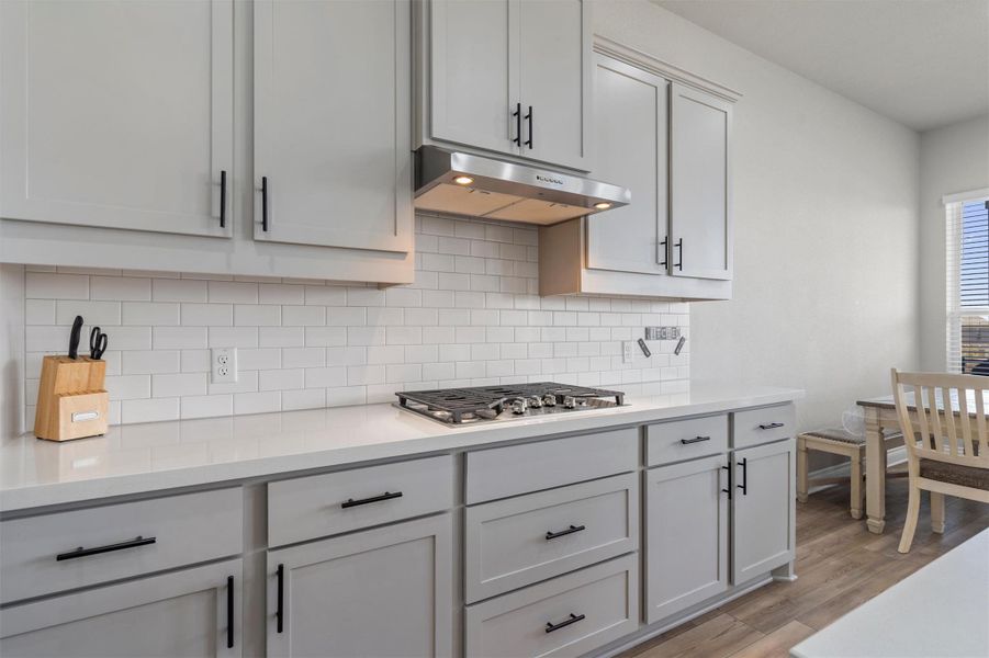Streamlined cabinetry and timeless subway tile define this functional cooking space.