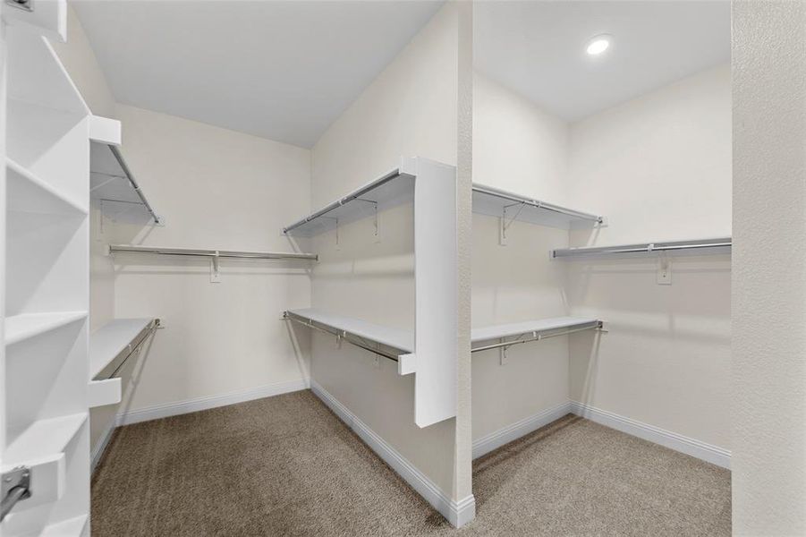 Walk in closet featuring dark colored carpet Walk in closet featuring dark colored carpet