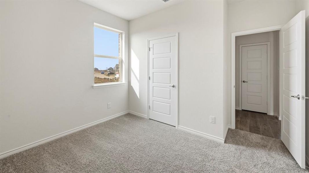 Unfurnished bedroom featuring carpet and baseboards