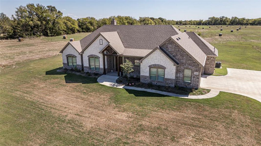 French country inspired facade with a front yard and a rural view