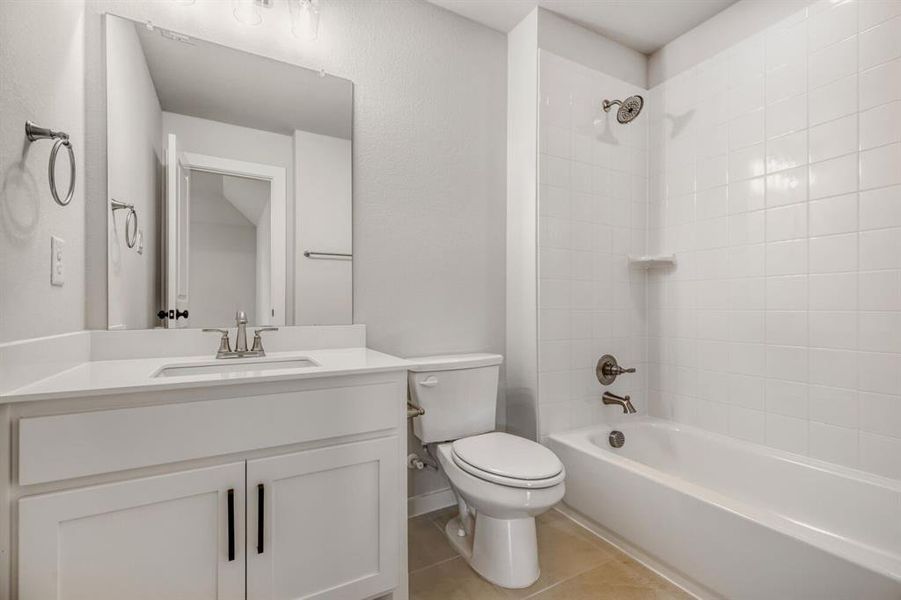 Bathroom featuring  shower combination, vanity, and light tile patterned floors