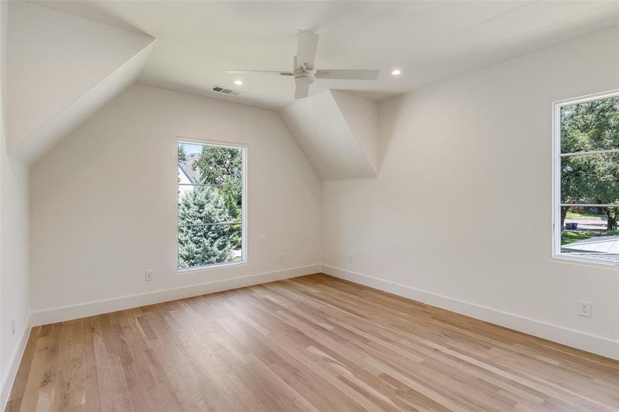 Additional living space with light wood-style floors, vaulted ceiling, recessed lighting, and a ceiling fan Additional living space with light wood-style floors, vaulted ceiling, recessed lighting, and a ceiling fan