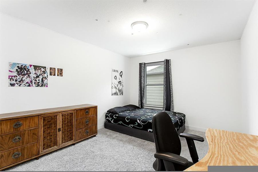 Bedroom with light colored carpet and baseboards