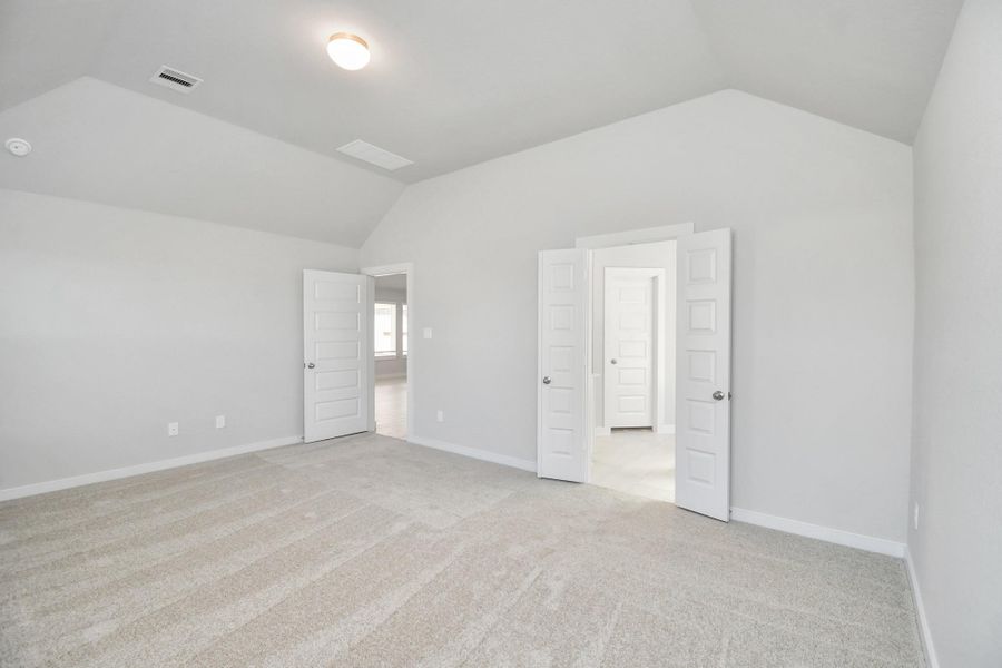 Escape and relax in the exquisite primary suite, a haven to unwind after a long day. The spacious room, boasts plush carpeting, soothing paint tones, high ceilings, and expansive windows adorned with privacy blinds. Sample photo of completed home with similar floor plan. Actual colors and selections may vary.