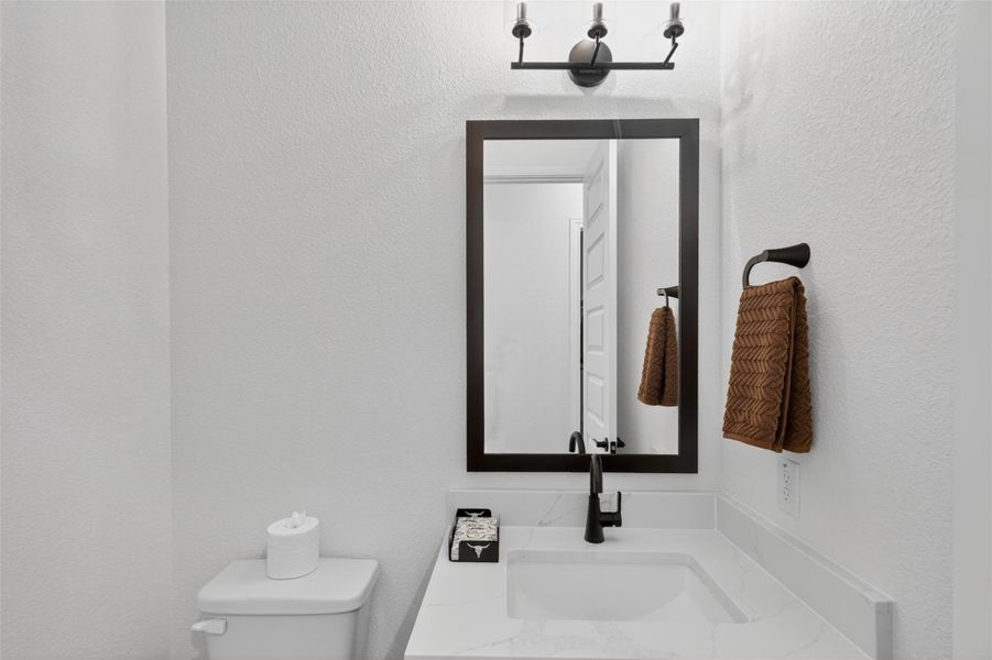 A well-appointed bathroom vanity features a broad mirror, elegant dark faucet, and pristine countertop. A well-appointed bathroom vanity features a broad mirror, elegant dark faucet, and pristine countertop.
