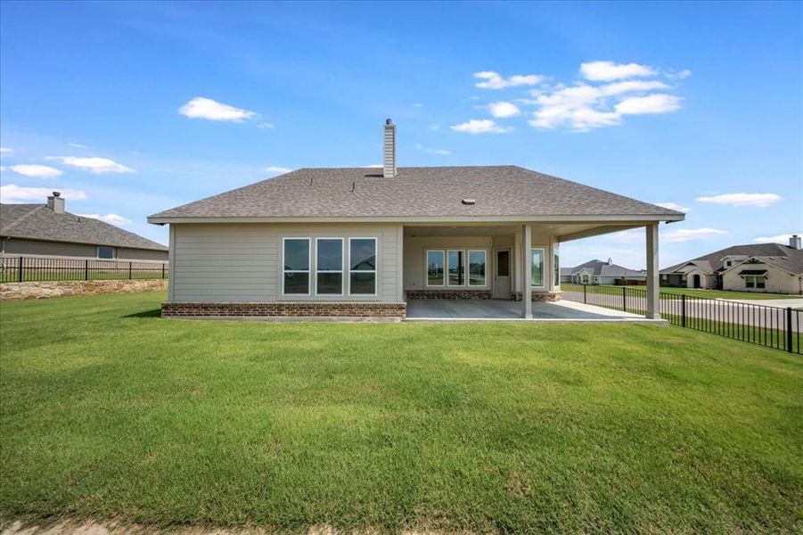 Rear view of property featuring a patio, brick siding, and roof with shingles Rear view of property featuring a patio, brick siding, and roof with shingles