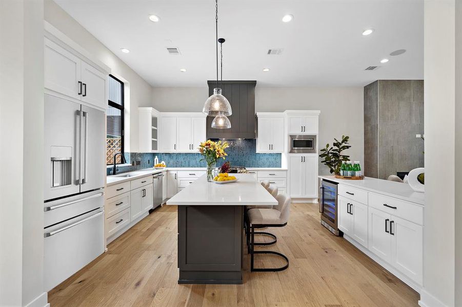 Guests can be front and center at the dining island illuminated by glass pendants overhead.