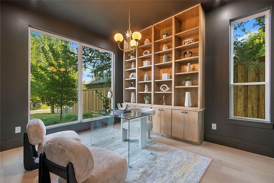 Living area with healthy amount of natural light, light wood-style flooring, and a chandelier Living area with healthy amount of natural light, light wood-style flooring, and a chandelier