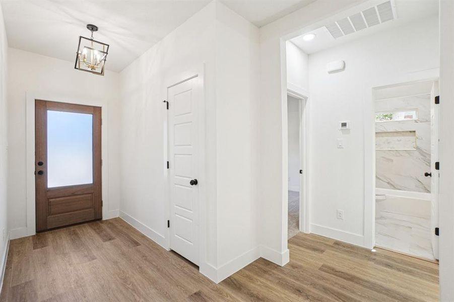 Entrance foyer featuring light wood finished floors, a chandelier, and recessed lighting Entrance foyer featuring light wood finished floors, a chandelier, and recessed lighting