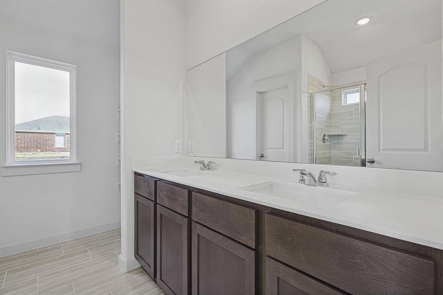 Bathroom featuring vanity, a wealth of natural light, and walk in shower