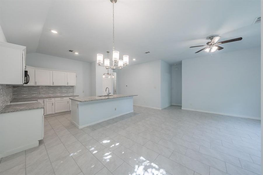 Kitchen featuring decorative backsplash, ceiling fan, a chandelier, decorative light fixtures, and white cabinets Kitchen featuring decorative backsplash, ceiling fan, a chandelier, decorative light fixtures, and white cabinets