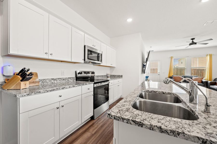 Contemporary kitchen featuring white cabinetry and granite countertops