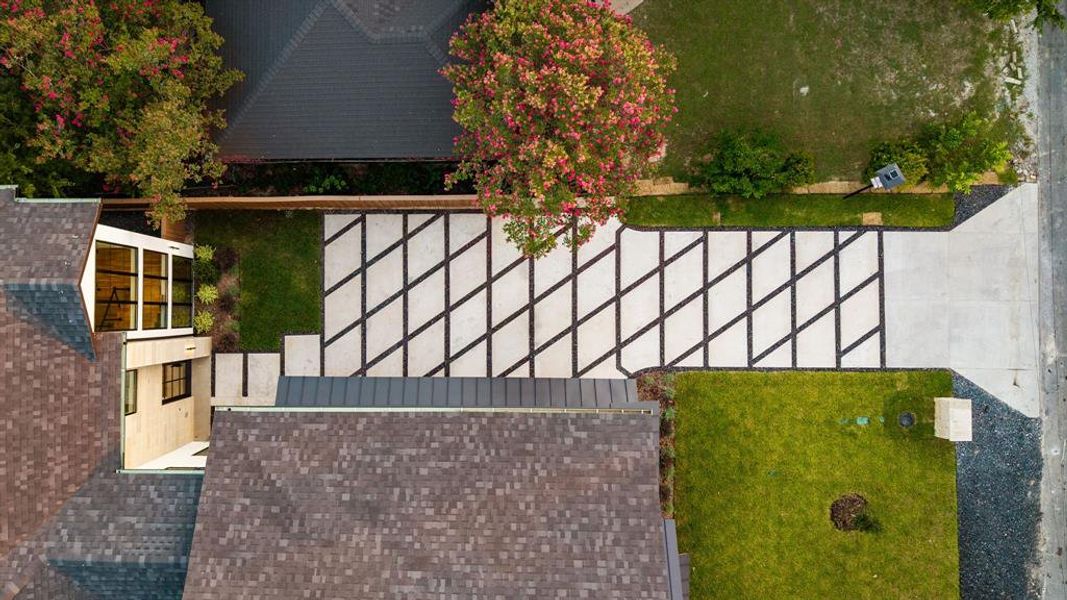 Modern drive featuring a distinctive geometric pattern, concrete paver accents, and contrasting dark aggregate
