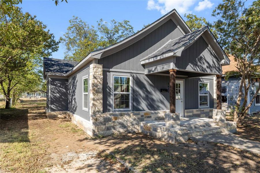 View of front facade with stone siding and a shingled roof View of front facade with stone siding and a shingled roof